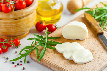 Mozzarella with tomatoes and arugula, caprese salad cooking