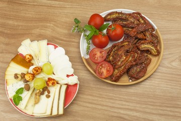 Spicy dried tomatoes marinated in olive oil. Delicious delicacy. Refreshments at the party. Sun-dried tomatoes with olive oil, background. Healthy food.
