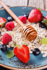 Muesli with fresh berries and hone, on the blue plates Healthy Breakfast.selective focus