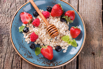 Muesli with fresh berries and hone, on the blue plates Healthy Breakfast.selective focus