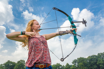 Young woman shooting archery with compound bow and arrow