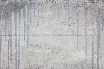 concrete wall with cement drips and copyspace in the middle.