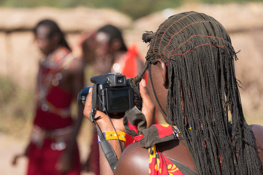 Masai woman using camera in traditional dress