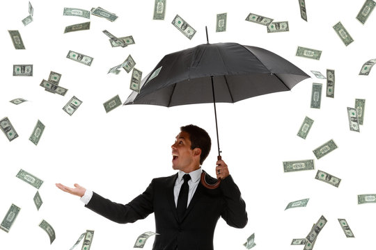 Excited businessman in a money rain storm
