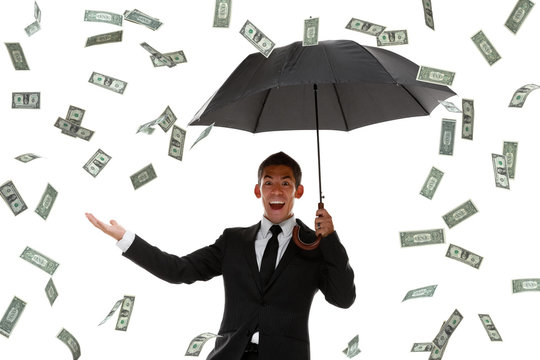 Excited businessman holding hand out in a money rain storm