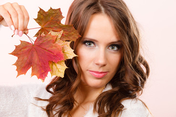 Pretty autumnal girl with maple leaves in hand