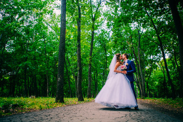 Fototapeta premium beautiful young couple posing in the park on a background of trees