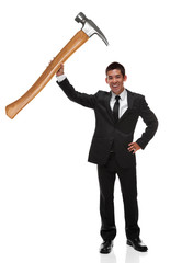 Businessman holding a gaint hammer up as a business tool concept