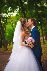 beautiful young couple posing in the park on a background of trees