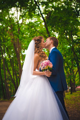 beautiful young couple posing in the park on a background of trees