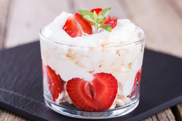 Eton Mess - Strawberries with whipped cream and meringue in a glass beaker. Classic British summer dessert.selective focus