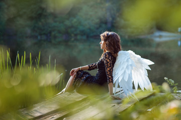 On the pier sits angel girl.