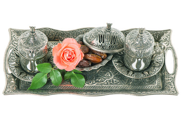 Tea table setting withdates, mint leaves and rose flower