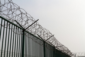 Razor wire on top of green fence guarding French ferry terminal.