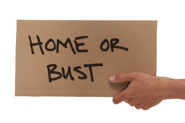 Hand holding up a cardboard home or bust sign