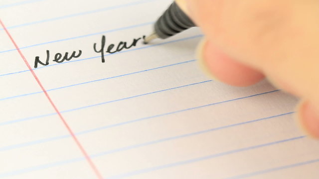 writing down your new years resolutions on paper - different angle