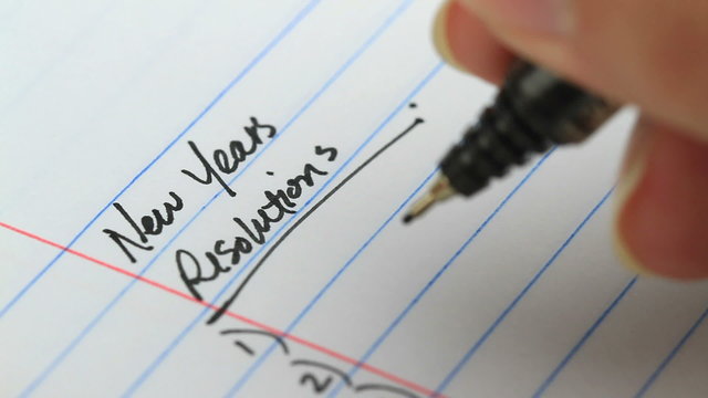 writing down your new years resolutions on paper - different angle