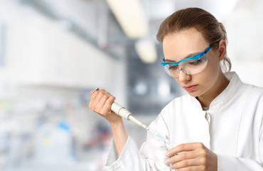 Young female tech or scientist loads sample with automatic pipet