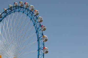 Blue ferriswheel in front of blue sky on a sunny day