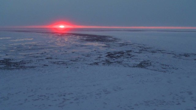 An aerial over the frozen arctic region of Hudson bay, Canada at sunset or sunrise.