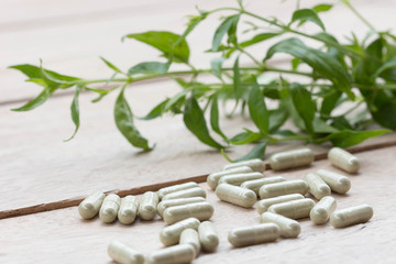 Fototapeta na wymiar Herbal medicine capsule on a wooden floor.