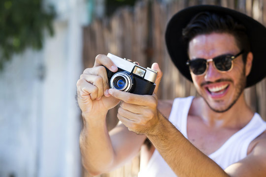 Hipster young man with vintage camera outdoors