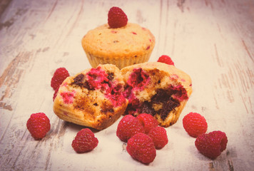Vintage photo, Fresh baked muffins with chocolate and raspberries on wooden background, delicious dessert
