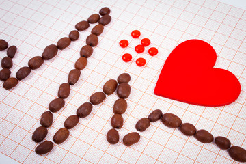 Cardiogram line of coffee grains, red heart and supplement pills, medicine and healthcare concept