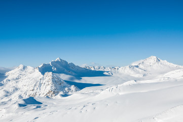 Beautiful winter landscape with snow-covered mountains and blue