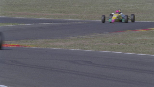 Formula cars race on a circuit.