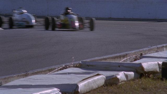 Formula cars compete on a circuit track.