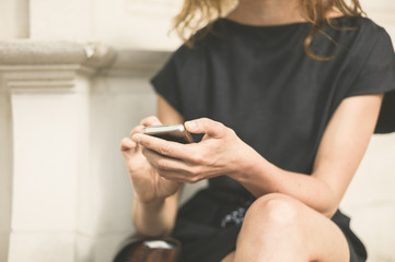 Young woman using phone outside in city