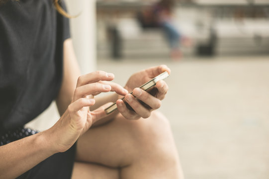 Young woman using phone outside in city