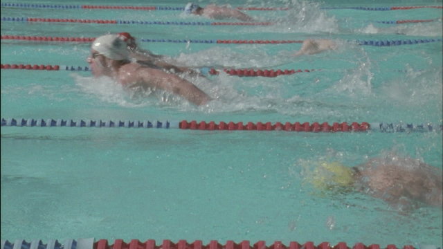 A group of men race to the other side of the pool.