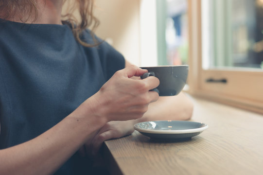 Woman having coffee by window in cafe