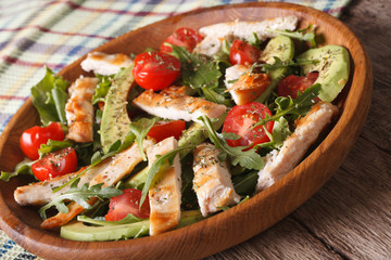 Chicken salad with avocado, arugula and cherry tomatoes close up