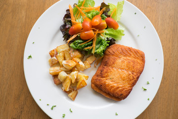 salmon steak with roast potato and salad