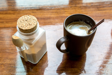 Cappuccino in brown cup on wooden table
