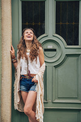Happy young woman in boho clothes standing outdoors