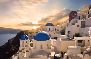 Traditional white architecture in Oia Santorini, illuminated by a beautiful sunset in Greece - Europe - obrazy, fototapety, plakaty