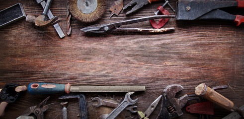 grungy old tools on a wooden background