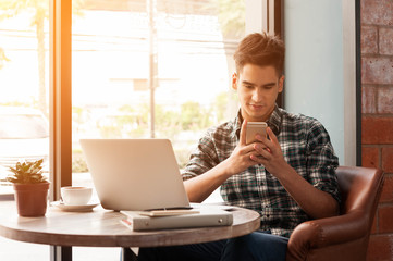 Businessman using smartphone and laptop with tablet and pen on w