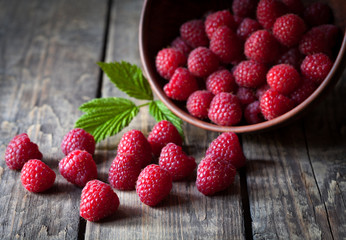 Fresh organic healthy raspberry with mint leaves in clay dish on
