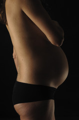Fototapeta premium kobieta w ciąży z czarnym tłem