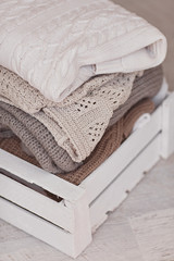 Fototapeta na wymiar White wool sweaters in wood box on white wood floor