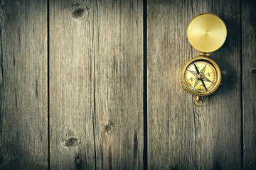 Antique compass over wooden background
