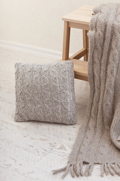 Natural small wooden ladder on white wood floor with grey pleid