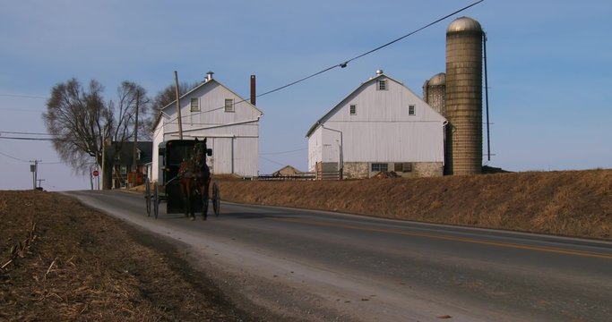 An Amish horse cart travels along a road in rural Pennsylvania.