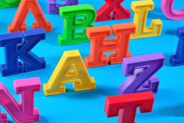 Plastic colorful alphabet letters on a blue background