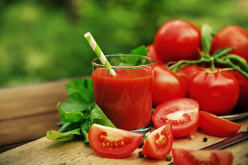 Fresh tomato juice on wooden background